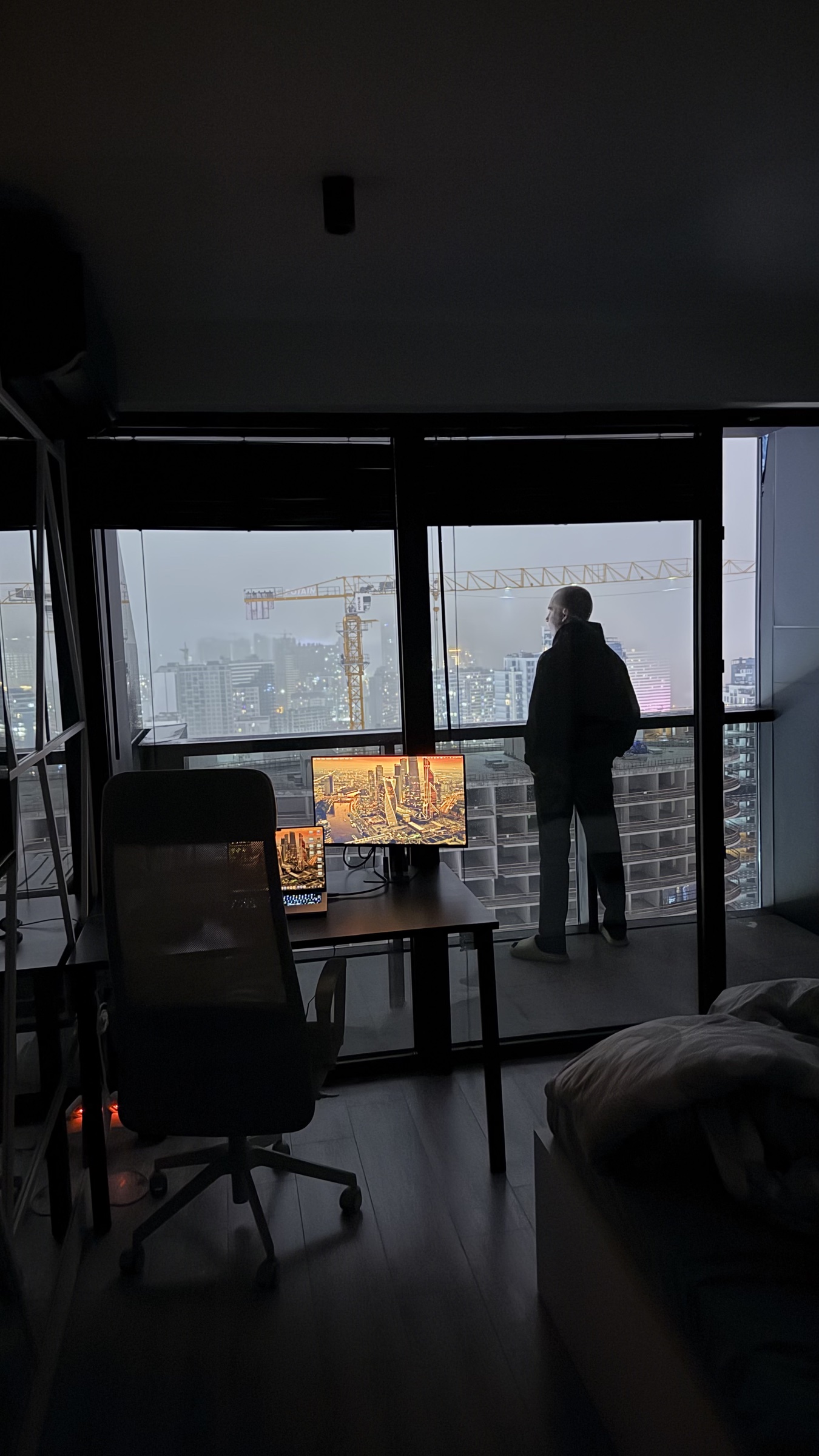A creator looking out over the city skyline at dusk